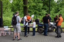 Dzieci oraz ich opiekunowie przy policyjnym stoisku profilaktycznym na terenie krakowskiego Zoo
