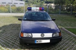 Przód pojazdu oznakowanego jako policyjny o barwach i oznaczeniach stosowanych w latach 90