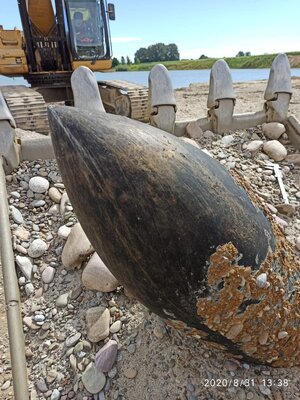 Zbliżenie na pocisk wystający ze żwiru w łyżce koparki