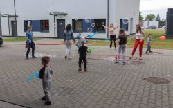 Dzieci biegają za bańkami mydlanymi. Drugie zdjęcie
