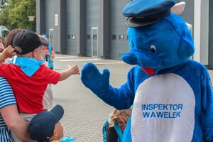 Policyjna maskotka "Wawelek" przybija piątkę dziecku