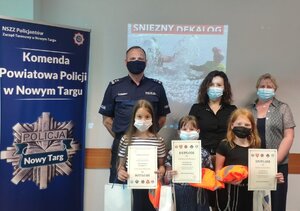 Zdjęcie grupowe z wyróżnionymi dziewczynkami i opiekunem