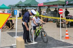 Tor dla rowerzystów na pustyni. Policjant ruchu i dziecko na rowerze