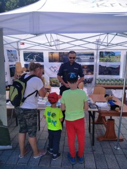 Policjant rozmawia z dziećmi. Pod namiotem. Krynica