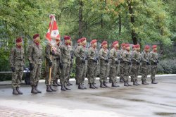Żołnierze w dwuszeregu stojący wraz z pocztem sztandarowym