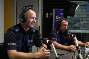 policjant wypowiada się do radia, w tle znany redaktoe