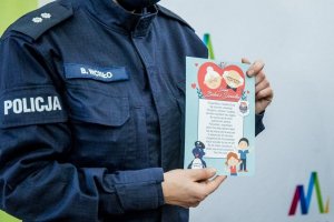 Policjantka prezentująca kartkę edukacyjną