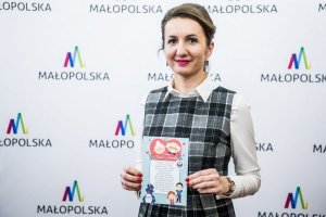 Przedstawiciel Urzędu Marszałkowskiego Województwa Małopolskiego prezentuje kartkę edukacyjną