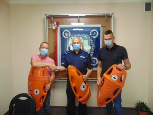 KPP Oświęcim. Prezes WOPR, Komendant i Skarbnik Wopr podczas przekazania bojek ratunkowych