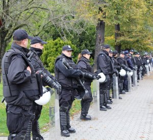 policjanci w pełnym umudurowaniu z tarczami podczas zabezpieczenia marszu