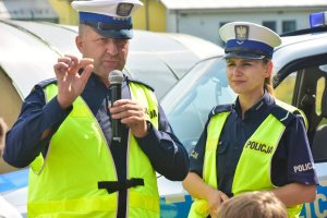 Policjant ruchu drogowego tłumacz w obecności policjantki informacje dzieciom