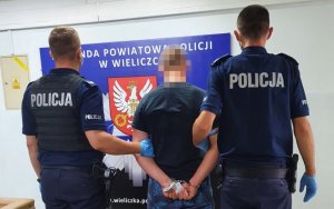 policjant prowadzi zatrzymanego