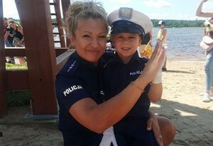 policjantka z dzieckiem ubranym w policyjny mundurek