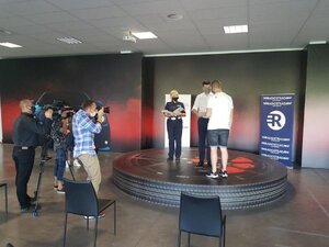 Na zdjęciu Pan Marszałek Łukasz Smółka wręcza mężczyźnie certyfikat Akademii Dobrych Kierowców. Obok stoi policjantka ruchu drogowego trzymająca w ręku pozostałe certyfikaty. Z lewej strony zdjęcia fotoreporterzy.