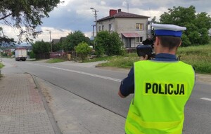 policjant drogówki w kamizelce odblaskowej z laserowym miernikiem prędkości