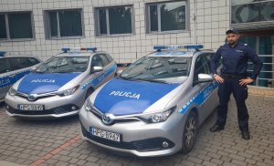 dzielnicowy z Komisariatu VI Policji w Krakowie stoi przy oznakowanym radiowozie