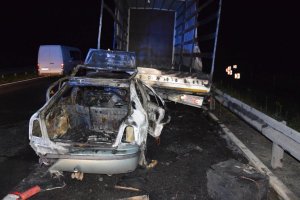 Spalony samochód osobowy oraz tylna część naczepy w samochodzie ciężarowym, widok z tyłu