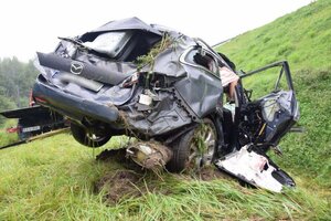 Zniszczony ciemny samochód na pasie zieleni