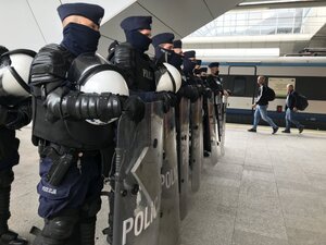 policjanci z opuszczonymi tarczami na dworcu