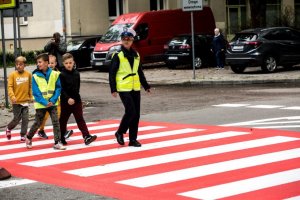 Policjantka przeprowadza dzieci przez ulicę