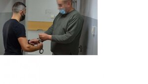 policjant nakłada kajdanki podejrzanemu