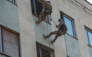 policjanci zjeżdżają na linach po budynku