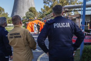 policjant i strażak obserwuje działania jednostki straży pożarnej