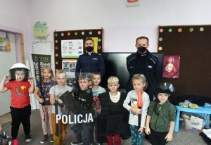 Policjanci oraz dzieci policyjnymi tarczami oraz latarkami