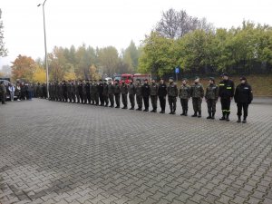 Uczniowie w mundurach stoją w szeregu na płycie przed budynkiem MOSiR w Olkuszu