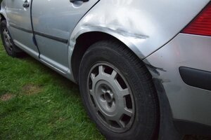 Widok uszkodzonej karoserii volkswagena z tyły z lewej strony