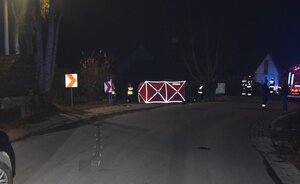 łuk drogi, w tle parawan straży pożarnej i funkcjonariusze pracujący na miejscy wypadku