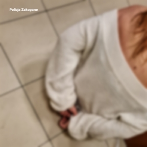 zdjęcie kobiety z kajdankami założonymi na ręce trzymane z tyłu