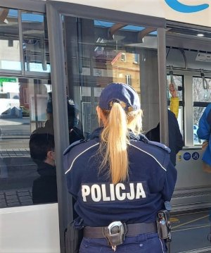 umundurowana policjantka w pobliżu miejskiego autobusu