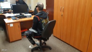 zatrzymany na krześle w policyjnym biurze