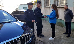 Przewodnicząca Rady Dzielnicy wręcza komendantowi komisariatu kluczyki do nieoznakowanego radiowozu