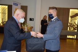Prezydent Miasta Krakowa przekazujący gratulacje oraz nagrody jednemu z wyróżnionych policjantów