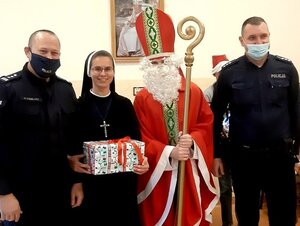 Komendant, policjant wraz z siostrą zakonną oraz Św. Mikołajem pozujący do wspólnego zdjęcia