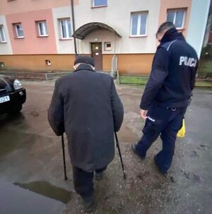 policjant obok staruszka poruszającego się o laskach