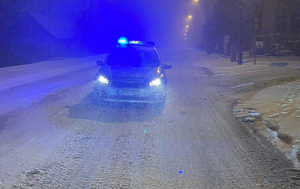 radiowóz na zaśnieżonej drodze