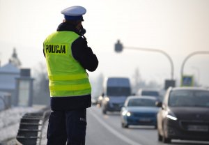 Policjant przy drodze mierzący prędkość