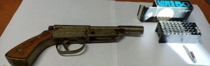 Pistolet konstrukcji metalowej z drewnianą rękojeścią oraz pudełko z amunicją