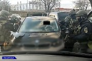 zamaskowani i uzbrojeni policjanci przy zatrzymanym samochodzie