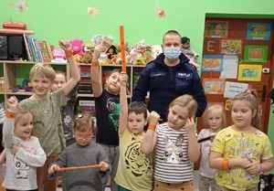 policjant z dziećmi podczas spotkania w przedszkolu