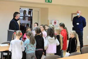 technik opowiada dzieciom o swojej pracy i pokazuje walizkę kryminalistyczną