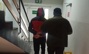 policjant prowadzi zatrzymanego