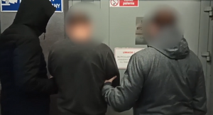 dwóch policjantów doprowadza zatrzymanego