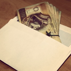 pieniądze wystające z białej koperty