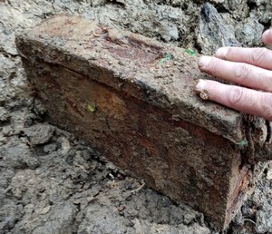 pordzewiała skrzynia leżąca na ziemi z ręką pirotechnika.