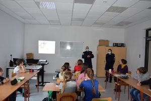 policjant i policjantka podczas zajęć z dziećmi w sali lekcyjnej