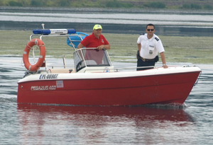 policjant i ratownik wodny na łodzi
